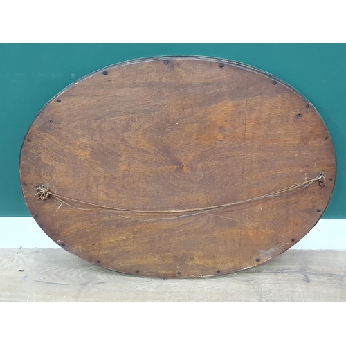 28 - An oval brass framed Wall Mirror with floral decoration and bevelled plate, 1ft 11