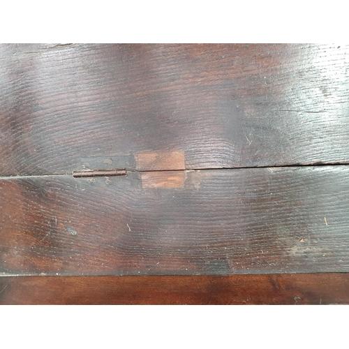 33 - An 18th Century oak Box Settle with panelled backrest above box seat, with turned arm supports, pane... 