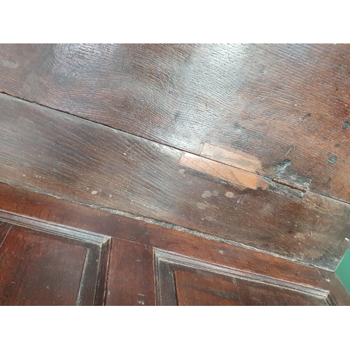 33 - An 18th Century oak Box Settle with panelled backrest above box seat, with turned arm supports, pane... 