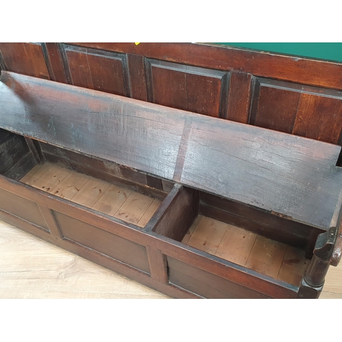 33 - An 18th Century oak Box Settle with panelled backrest above box seat, with turned arm supports, pane... 