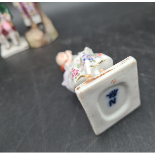 51 - A pair of Continental porcelain Seated Figures wit painted details, 3in,blue crowned N, another Figu... 
