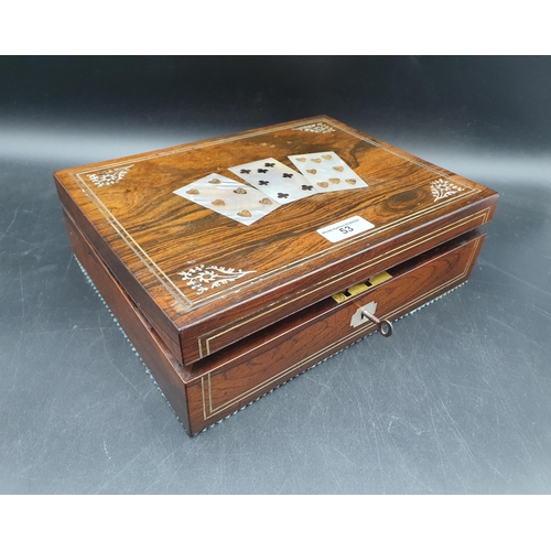 53 - A 19th century rosewood Games Box with mother of pearl inlay to the lid depicting playing cards, con... 