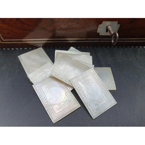 53 - A 19th century rosewood Games Box with mother of pearl inlay to the lid depicting playing cards, con... 