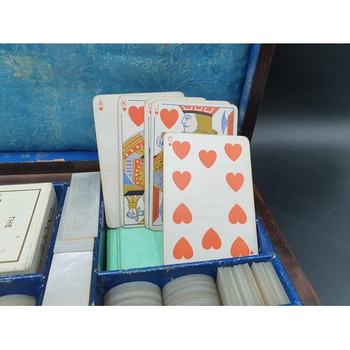 53 - A 19th century rosewood Games Box with mother of pearl inlay to the lid depicting playing cards, con... 