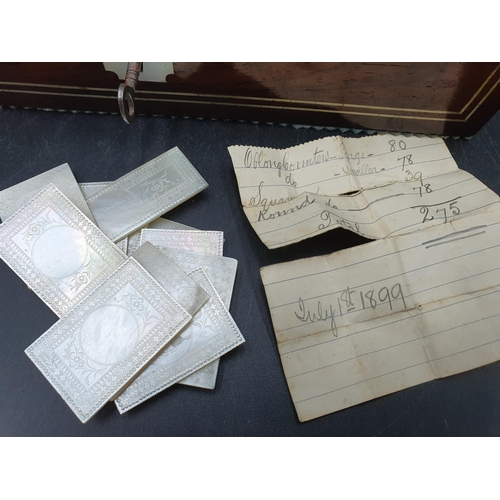 53 - A 19th century rosewood Games Box with mother of pearl inlay to the lid depicting playing cards, con... 