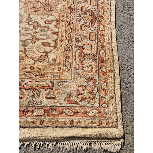 71 - A bordered Persian style Carpet, the central field with rust palmettes on a cream ground, pale green... 