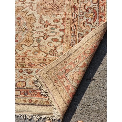 71 - A bordered Persian style Carpet, the central field with rust palmettes on a cream ground, pale green... 