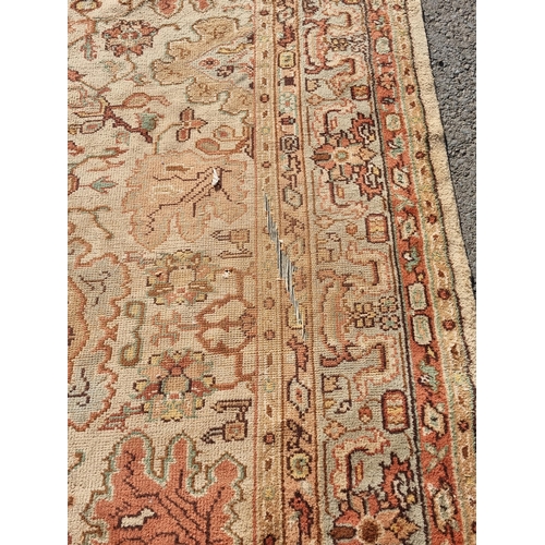 71 - A bordered Persian style Carpet, the central field with rust palmettes on a cream ground, pale green... 