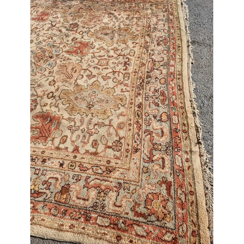 71 - A bordered Persian style Carpet, the central field with rust palmettes on a cream ground, pale green... 