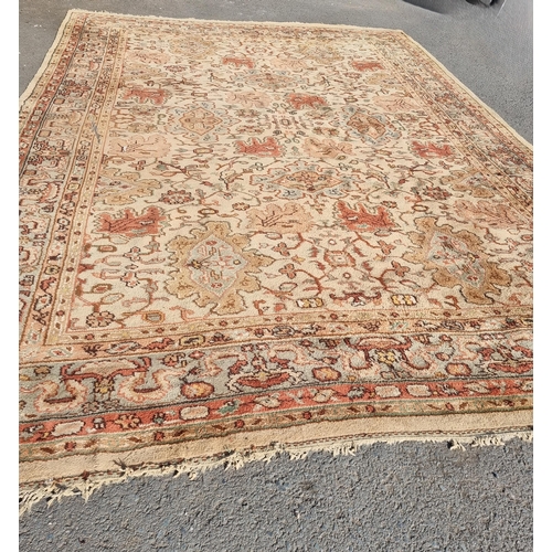 71 - A bordered Persian style Carpet, the central field with rust palmettes on a cream ground, pale green... 