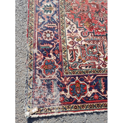 72 - A bordered Persian Carpet with medallion and corner design in blue, etc on a red ground, 11ft 8in x ... 