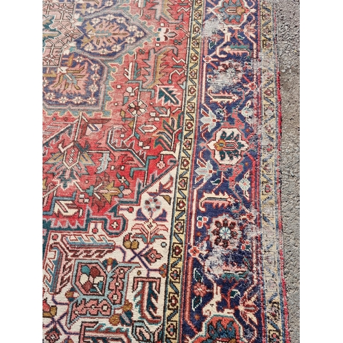 72 - A bordered Persian Carpet with medallion and corner design in blue, etc on a red ground, 11ft 8in x ... 