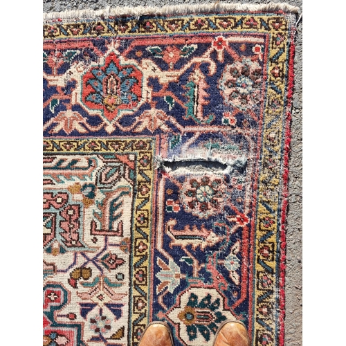 72 - A bordered Persian Carpet with medallion and corner design in blue, etc on a red ground, 11ft 8in x ... 
