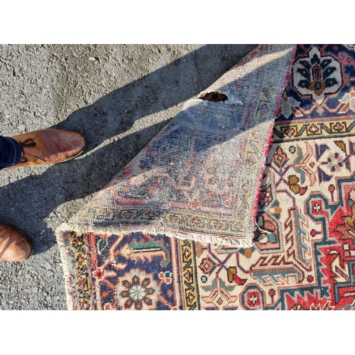 72 - A bordered Persian Carpet with medallion and corner design in blue, etc on a red ground, 11ft 8in x ... 