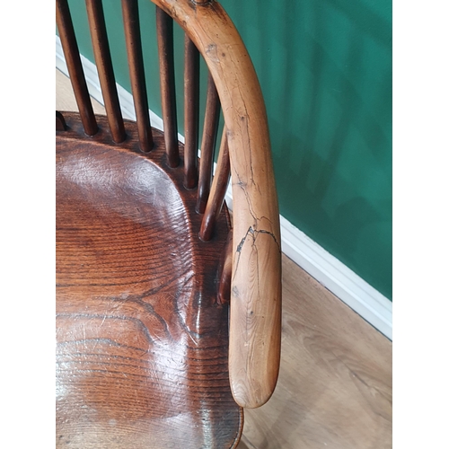 87 - An antique yew and elm Windsor Elbow Chair with shaped pierced splat, raised on turned supports unit... 