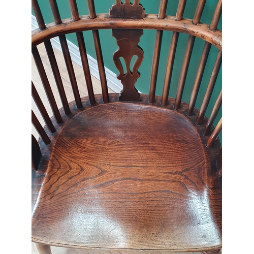 87 - An antique yew and elm Windsor Elbow Chair with shaped pierced splat, raised on turned supports unit... 