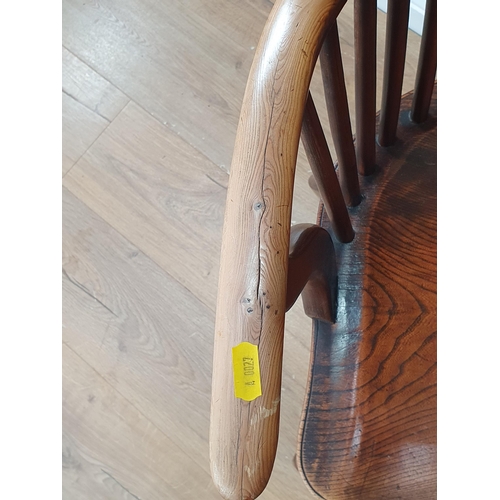 87 - An antique yew and elm Windsor Elbow Chair with shaped pierced splat, raised on turned supports unit... 