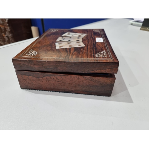 53 - A 19th century rosewood Games Box with mother of pearl inlay to the lid depicting playing cards, con... 