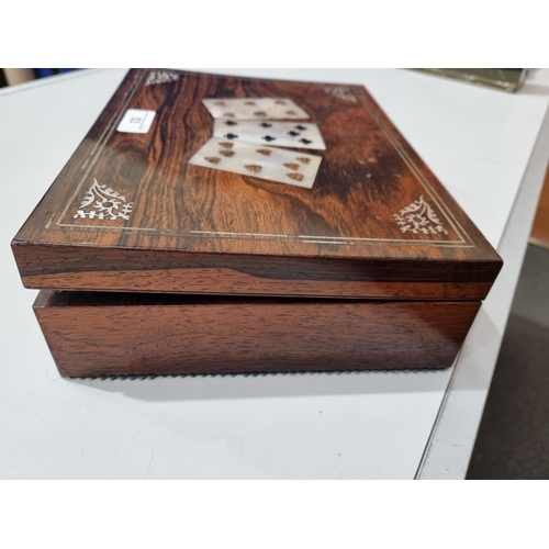 53 - A 19th century rosewood Games Box with mother of pearl inlay to the lid depicting playing cards, con... 