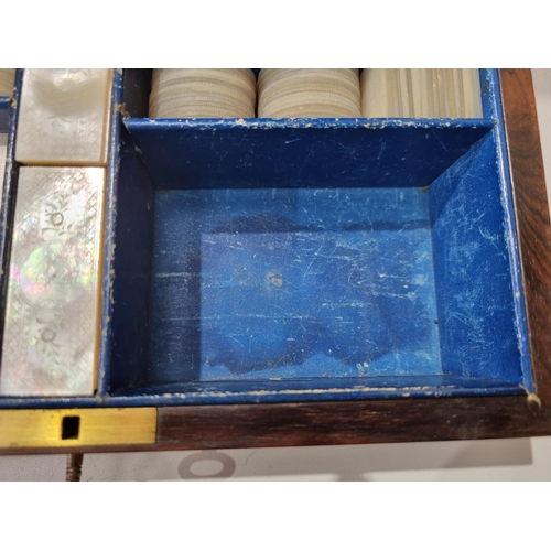 53 - A 19th century rosewood Games Box with mother of pearl inlay to the lid depicting playing cards, con... 