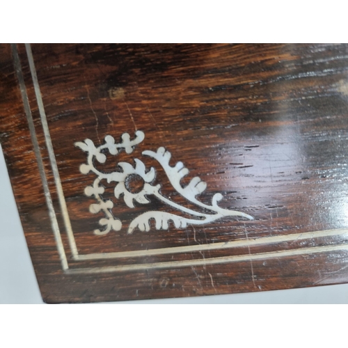 53 - A 19th century rosewood Games Box with mother of pearl inlay to the lid depicting playing cards, con... 