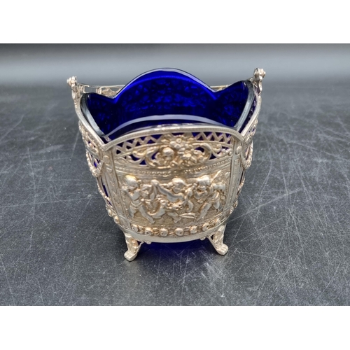 131 - A Continental silver Sugar Basket decorated cherubs and swags, etc, swing handle, blue glass liner. ... 
