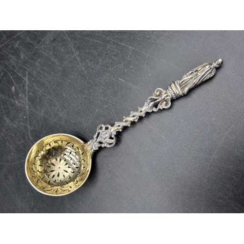 140 - A Victorian silver and parcel gilt Sifting Ladle with ornate stem having apostle finial, London 1870... 