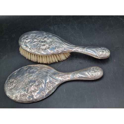 154 - An Edward VII Art Nouveau silver mounted Brush and Mirror floral embossed, Chester 1902 & 1904