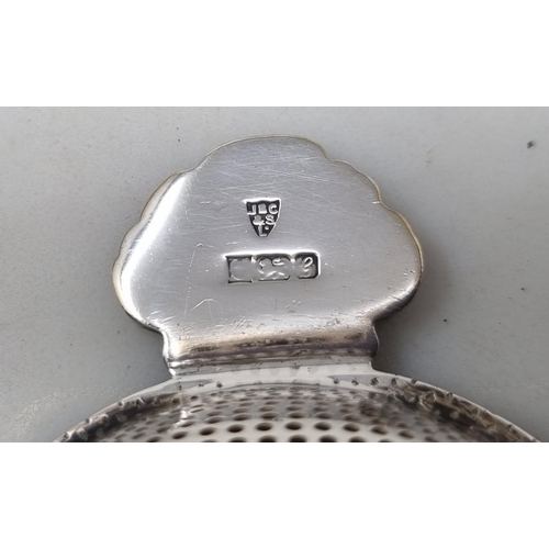163 - An Elizabeth II silver Tea Strainer with scallop edge and baluster ebonised handle, Birmingham 1981