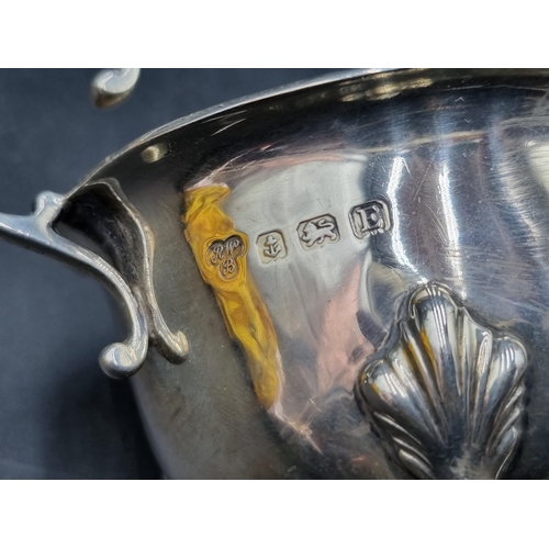 165 - A George V silver Sauce Boat with scroll handle  on hoof feet, Birmingham 1929, and another, Birming... 