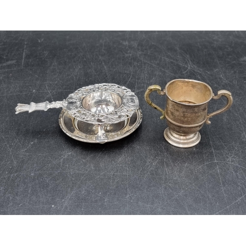 178 - A Dutch style Tea Strainer with windmill finial, on plated stand, and a small silver Trophy