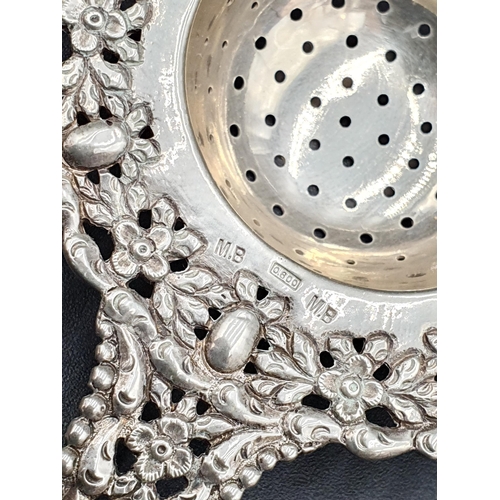 193 - A Continental low grade silver Tea Strainer with floral border, two silver Napkin Rings and two Trin... 