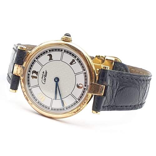254 - A Must de Cartier lady's Wristwatch, the circular white enamel dial having Arabic numerals in a gold... 