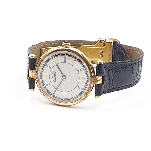 254 - A Must de Cartier lady's Wristwatch, the circular white enamel dial having Arabic numerals in a gold... 