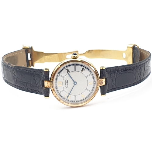 254 - A Must de Cartier lady's Wristwatch, the circular white enamel dial having Arabic numerals in a gold... 