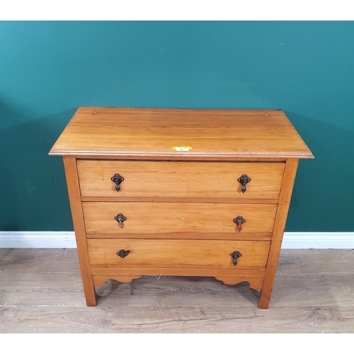 403 - A Satinwood chest of three long drawers raised on square supports with a shaped apron, 2ft 7