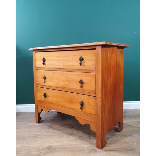 403 - A Satinwood chest of three long drawers raised on square supports with a shaped apron, 2ft 7