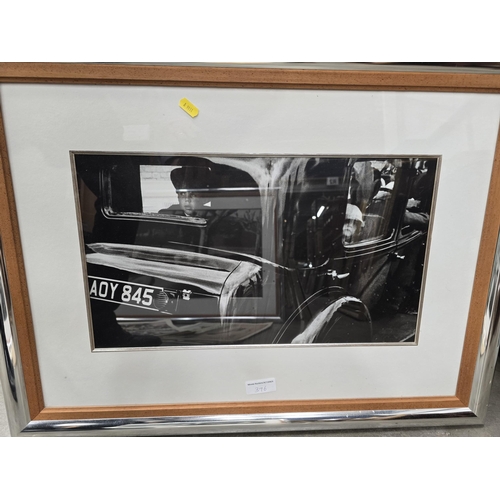 396 - A large framed Photograph, mid 20th Century scene with couple in a classic car, 22 x 32in another Ph... 
