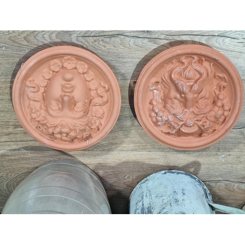 24 - A pair of terracotta relief Plaques, a stoneware Barrel, two Washing Dollies and a metal watering ca... 