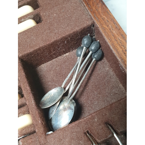 34 - An oak Canteen by Walker & Hall containing plated Cutlery and a set of six silver bean-handled Coffe... 