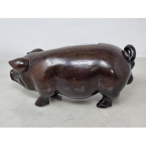 56 - An Oriental carved hardwood Boar with signature on an inset white metal panel, 6in CAB