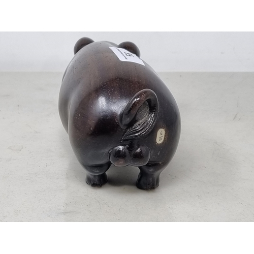 56 - An Oriental carved hardwood Boar with signature on an inset white metal panel, 6in CAB