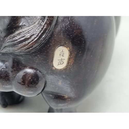 56 - An Oriental carved hardwood Boar with signature on an inset white metal panel, 6in CAB