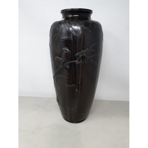 62 - A Japanese bronze Vase decorated birds amongst shrubs in low relief, 13in, signed