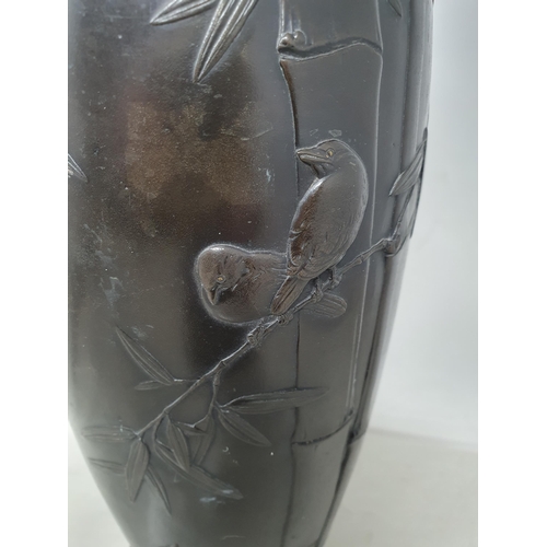 62 - A Japanese bronze Vase decorated birds amongst shrubs in low relief, 13in, signed