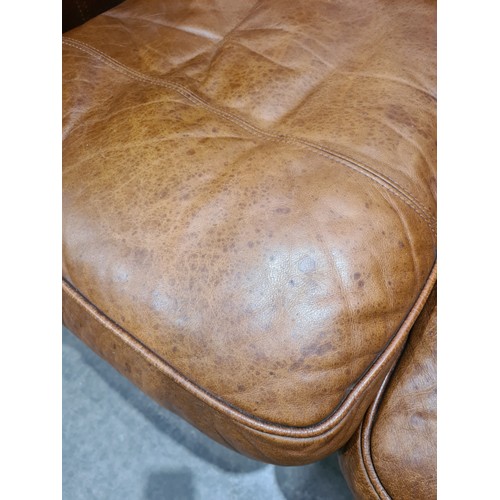 27 - A tan leather two seater Settee, raised on circular bun feet, 4ft 11