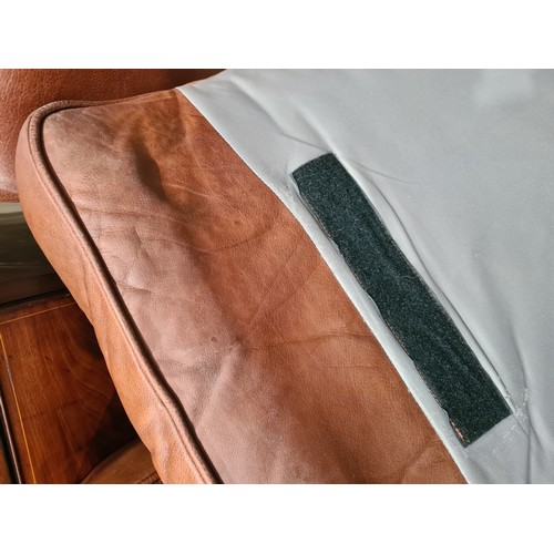 27 - A tan leather two seater Settee, raised on circular bun feet, 4ft 11