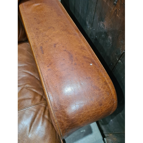 27 - A tan leather two seater Settee, raised on circular bun feet, 4ft 11