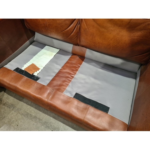 27 - A tan leather two seater Settee, raised on circular bun feet, 4ft 11