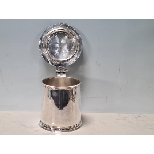 102 - A Charles 11 silver plain lidded Tankard with double scroll thumb piece, flat section lid, London 16... 